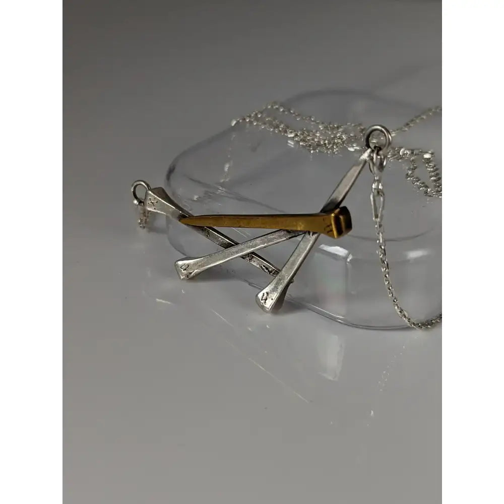 Silver steed elegant hoof nails necklace featuring a silver and gold nail pendant on a chain