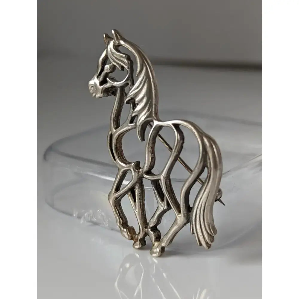 Silver steed elegant piaffe horse silver brooch with intricate filigree openwork and polished metallic finish