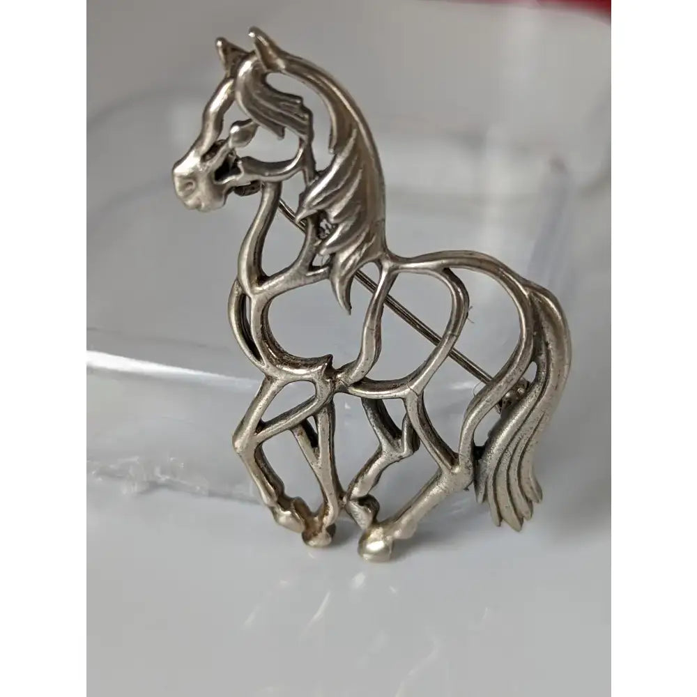 Silver steed elegant piaffe horse silver brooch with intricate filigree openwork and polished metallic finish