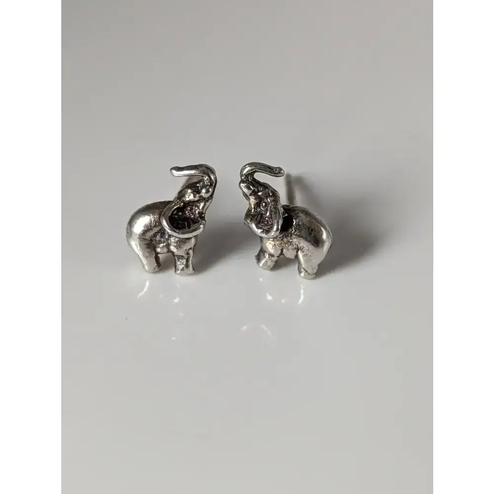 Silver steed elephant stud earrings with textured silver surfaces and raised trunks in elephant stud earrings style
