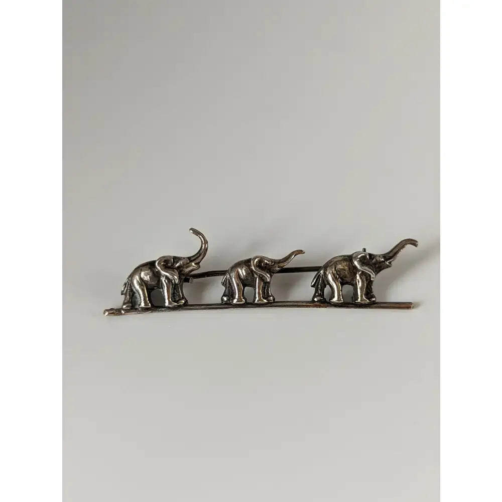 Silver steed elephants silver brooch with three detailed elephants raised trunks textured bodies in a line
