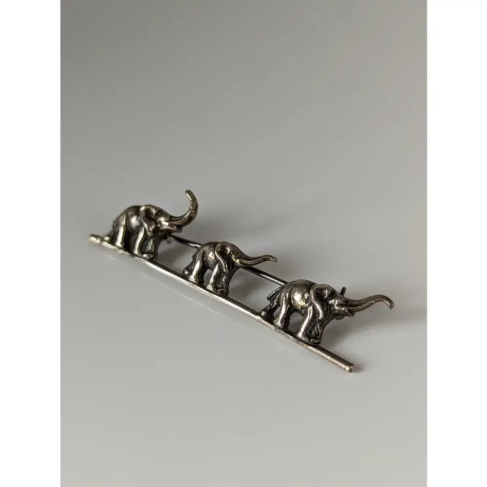 Silver steed elephants silver brooch with three detailed silver-toned elephants walking on a slender bar pin