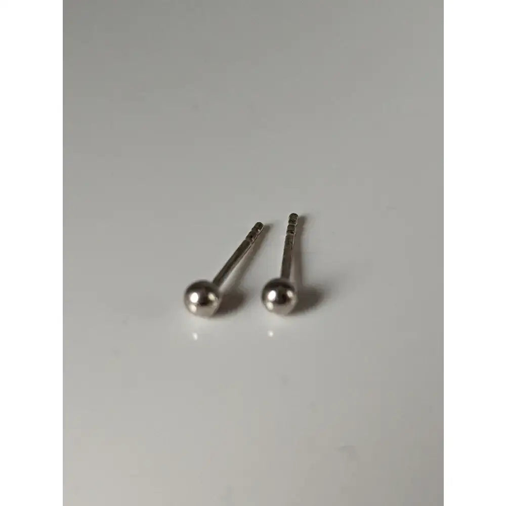 A pair of silver steed ball stud earrings with a sleek polished metallic finish and unique shape