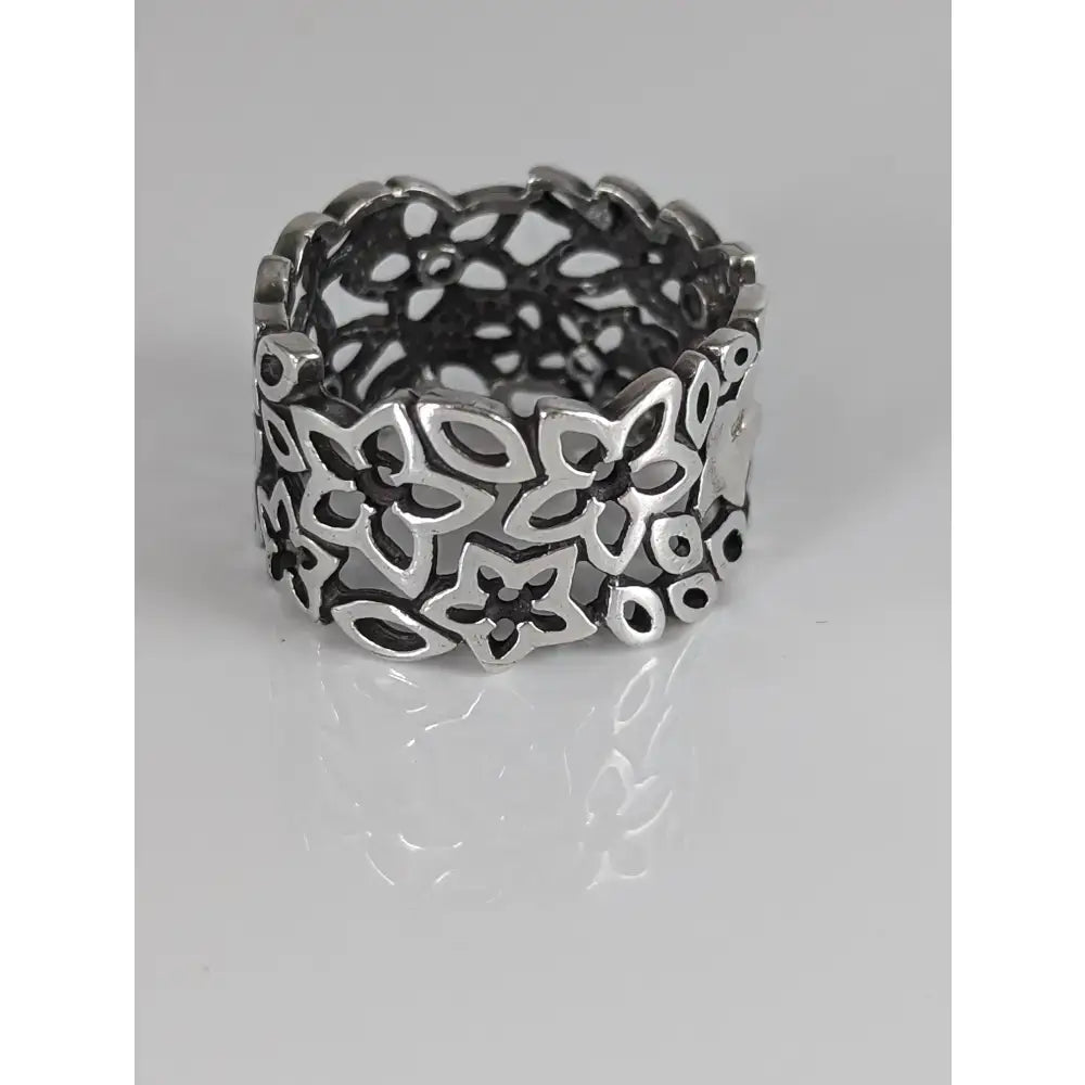 A wide sterling silver steed filigree ring with intricate openwork of stylized flowers and circular motifs