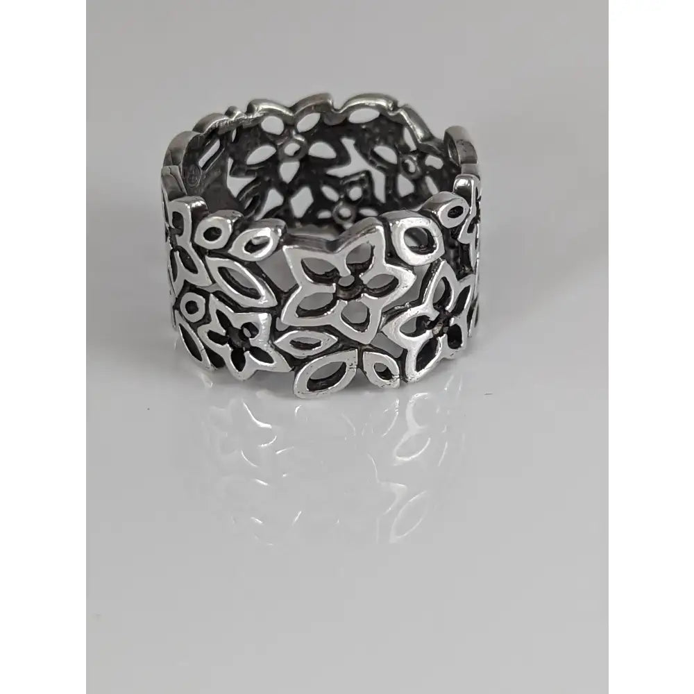 A wide silver steed filigree ring with intricate openwork floral petals and leaves in sterling silver