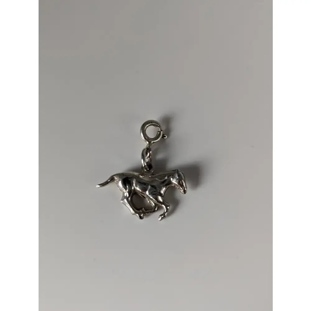 Silver charm featuring a polished metallic finish and detailed sculpted features in the silver steed galloping horse design