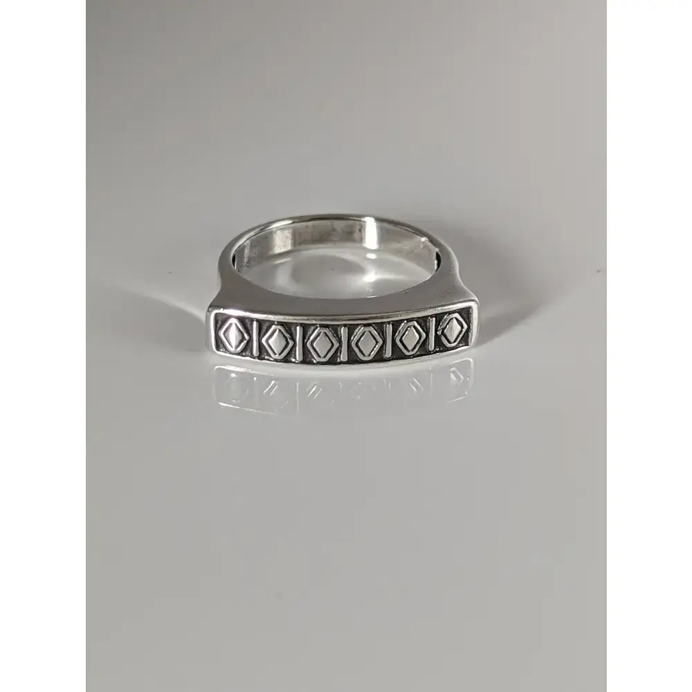 Silver steed greek theme ring with a radiant sheen and embossed diamond pattern on a rectangular silver face