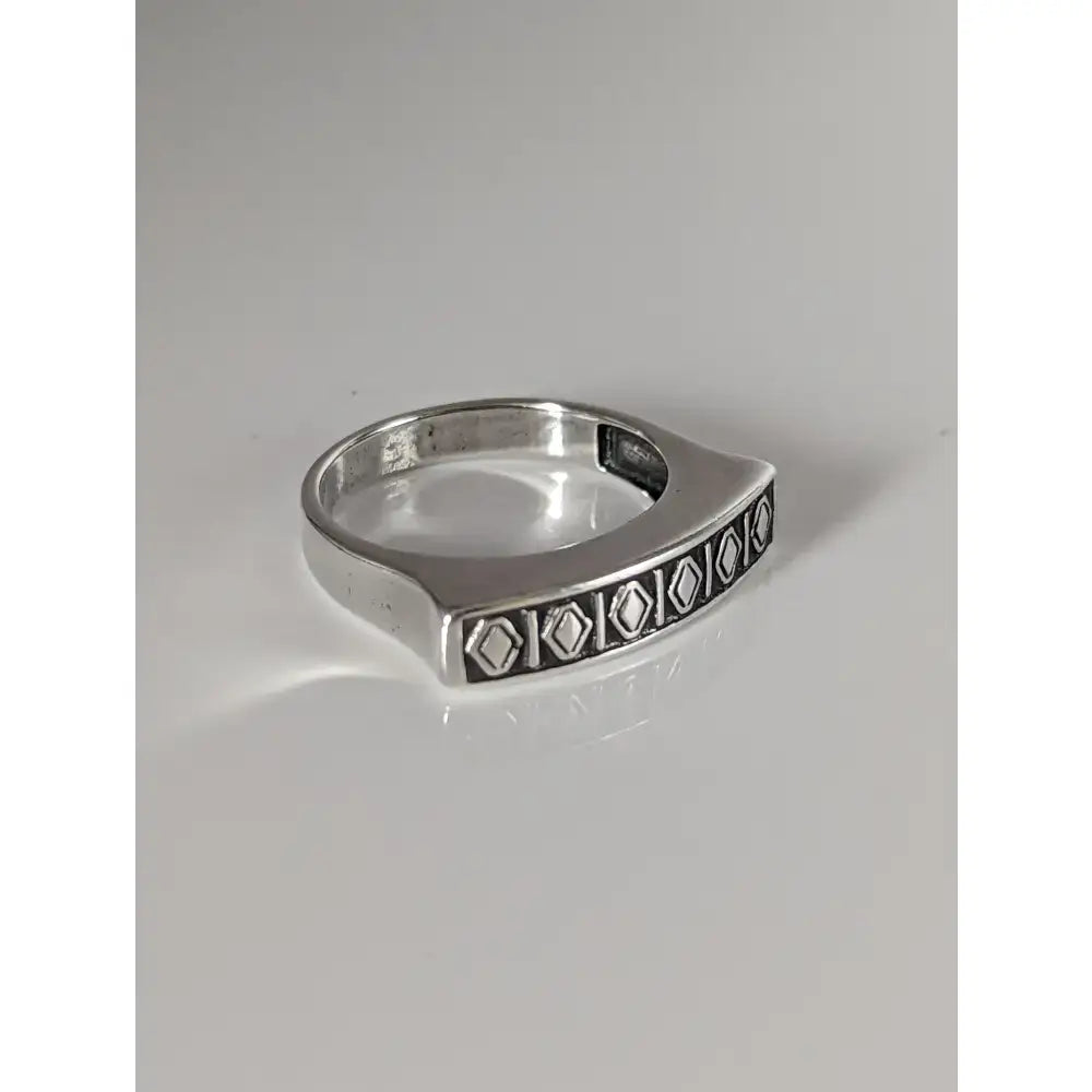 Silver steed greek theme ring with a radiant sheen and wide silver band featuring engraved diamond pattern edges