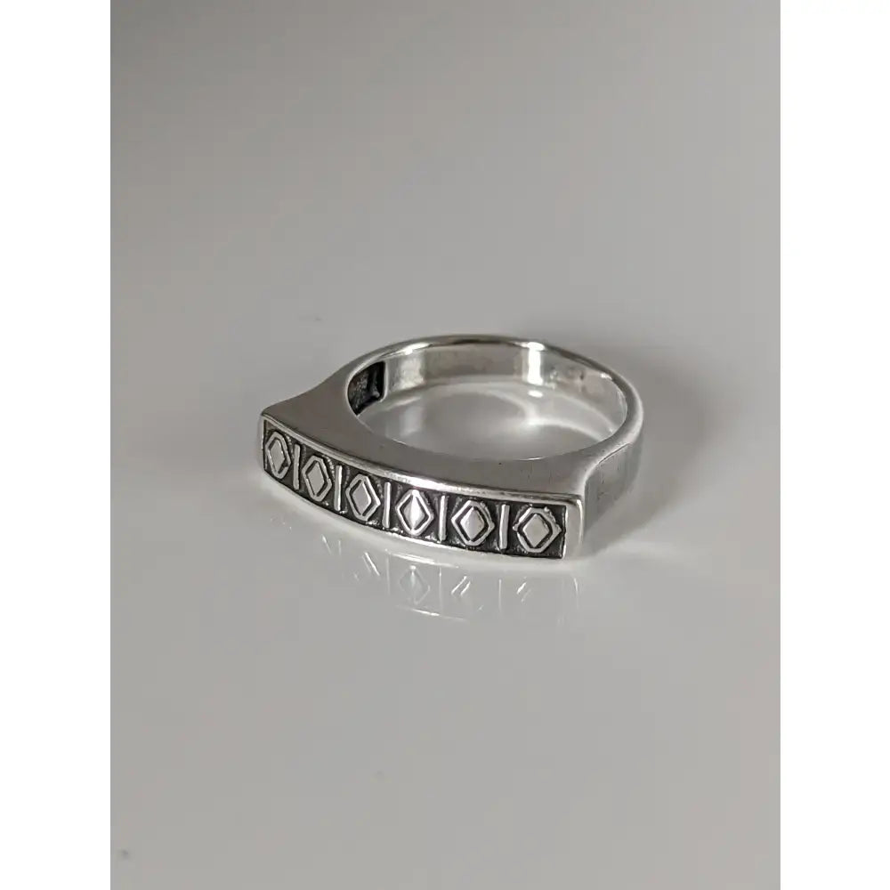 Silver steed greek theme ring with a radiant sheen and a wide embossed silver band featuring a diamond pattern