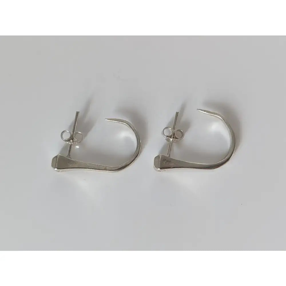 Silver steed hoofnail stud earrings are silver-toned minimalist hoops with sleek design and small decorative elements