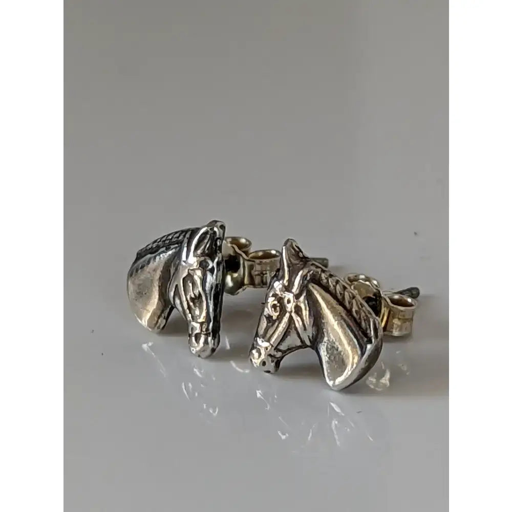 Silver steed horse head earrings with detailed facial features and textured manes in silver head stud earrings design