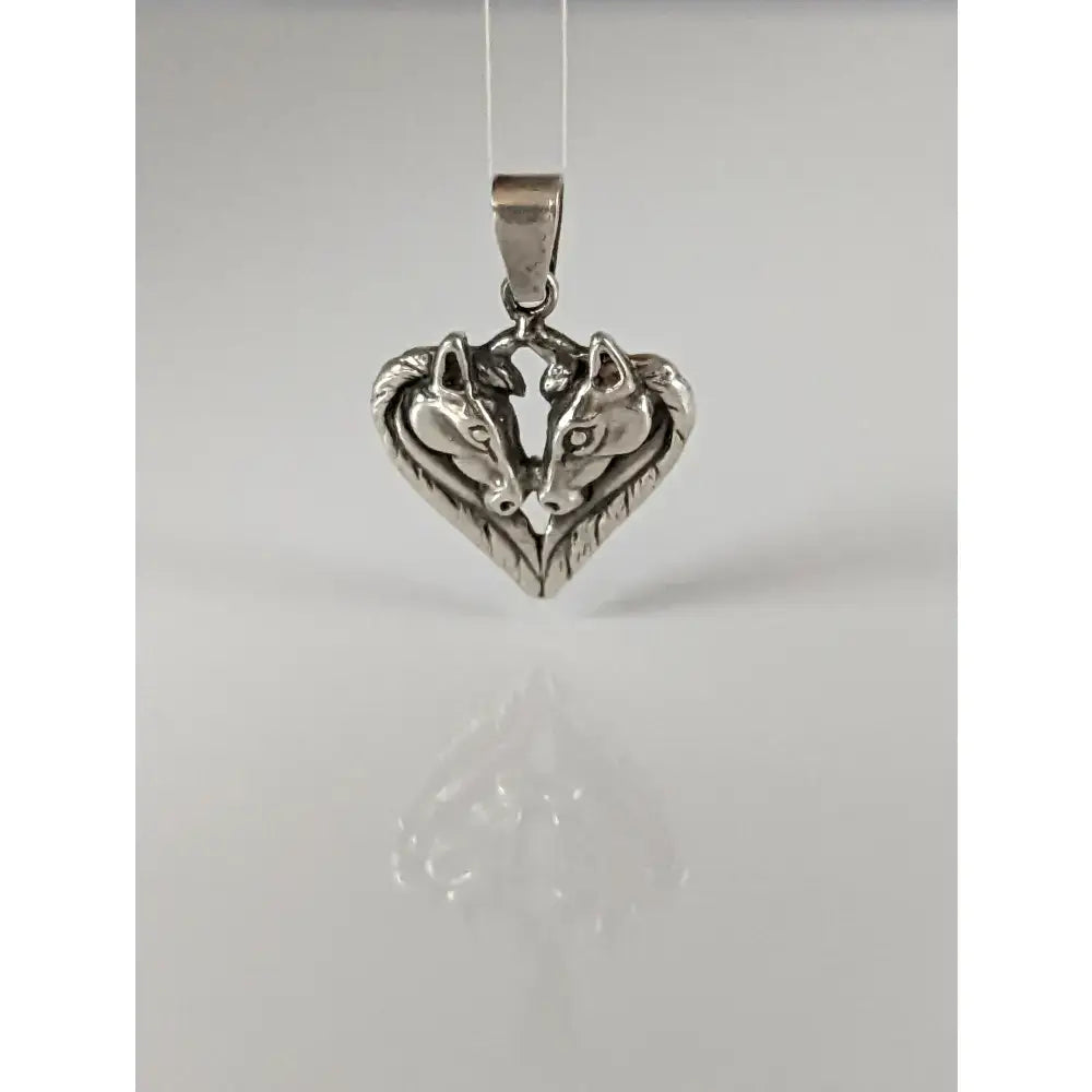 Silver steed horse heart pendant with two detailed silver wolf faces in a polished metal horse heart pendant