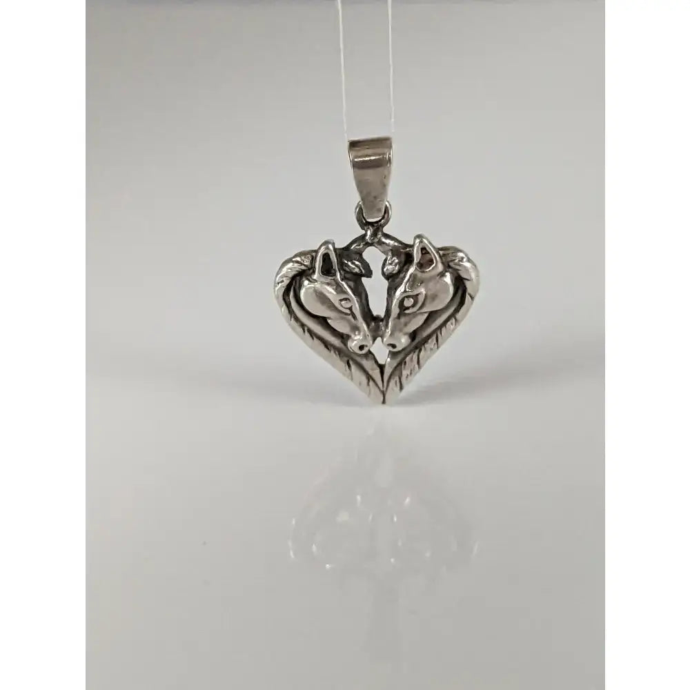 Silver steed horse heart pendant with polished silver horse heads facing each other in a detailed design
