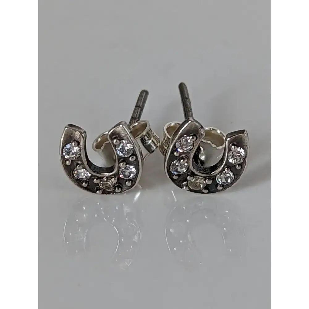 Silver steed horse shoe zirconia stud earrings featuring silver horseshoe shape with clear crystals