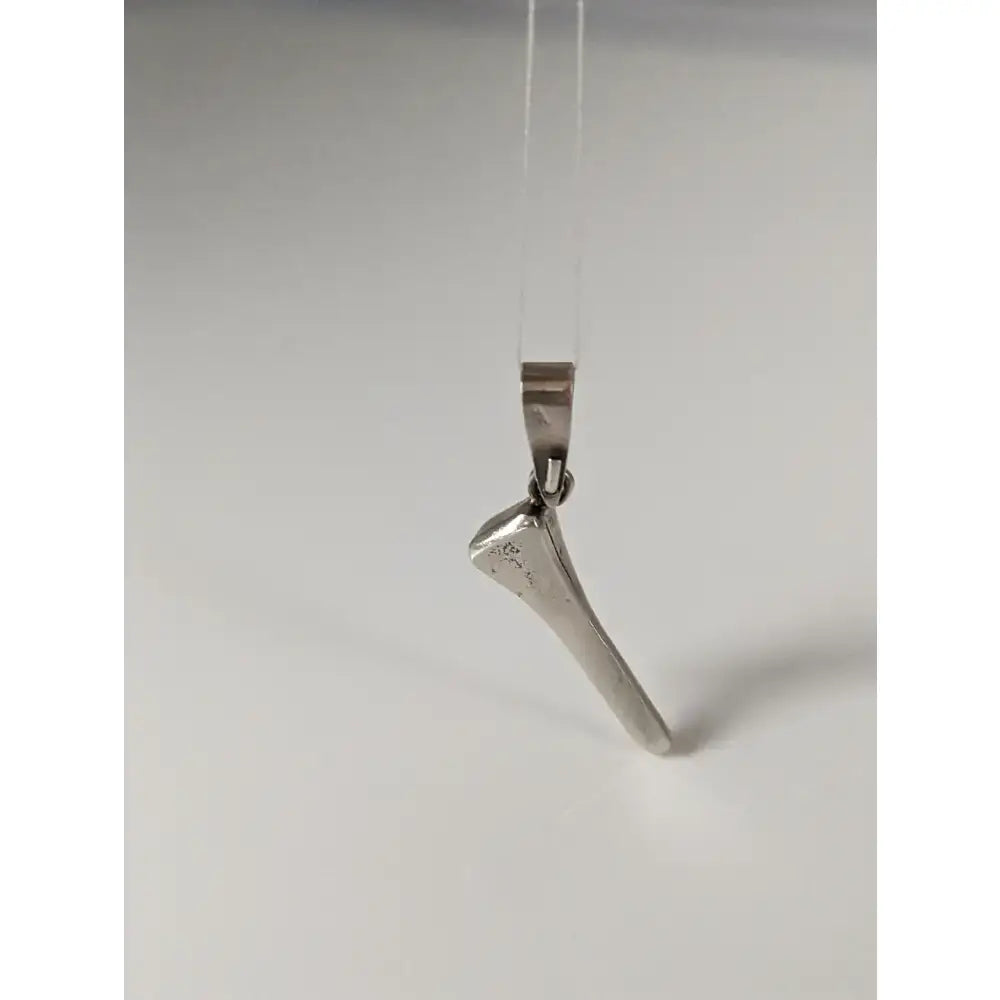 Silver steed silver pendant shaped like a horseshoe nail with polished metal finish on a clear cord