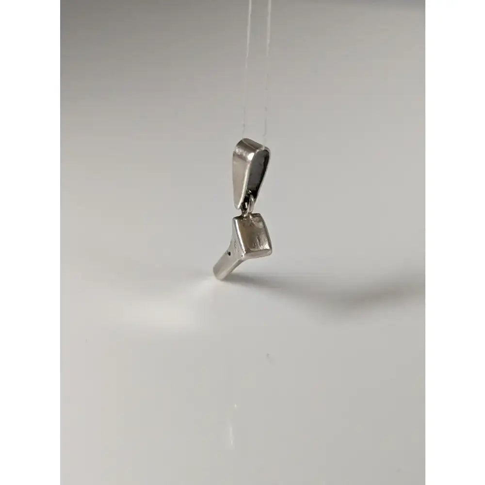Silver pendant shaped like a minimalist high-heeled shoe made from silver steed horseshoe nail metal