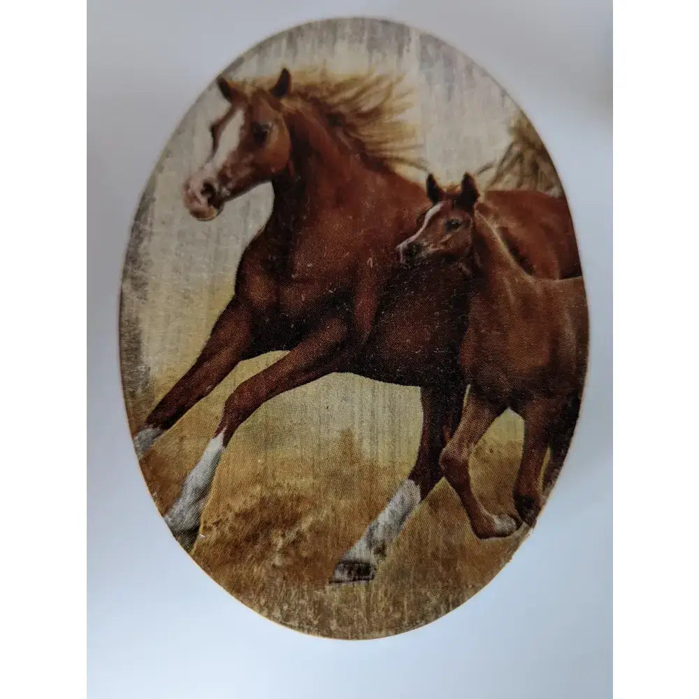 Oval-shaped embroidered tapestry on silver steed jewellery oval box shows two brown horses galloping on golden grass