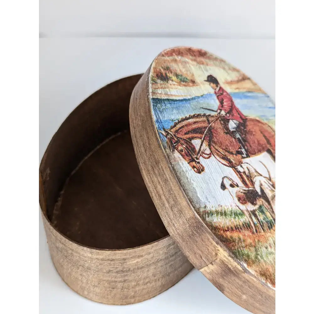 A rustic wooden silver steed jewellery oval box with a painted lid showing a red-coated horseman and hounds outdoors