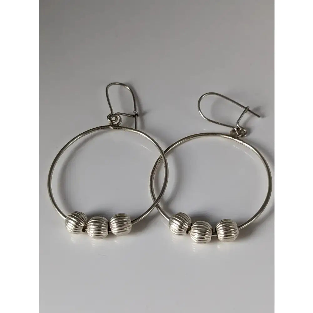 Silver steed loop buds dangling earrings in sterling silver with three textured silver beads on each hoop