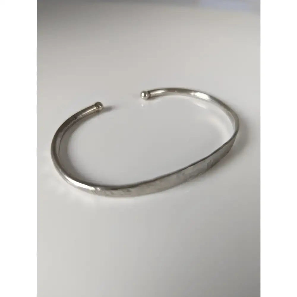 Silver steed magnetic solid silver bracelet featuring a sleek hammered cuff with rounded ends and minimalist design