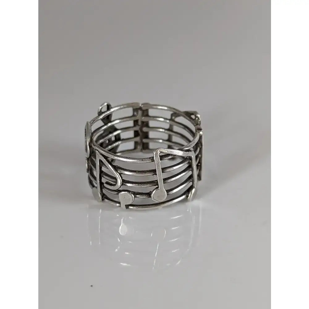 Silver steed music notes band is a silver-toned stretch ring with intricate musical notes and staff design perfect for equestrian jewelry fans