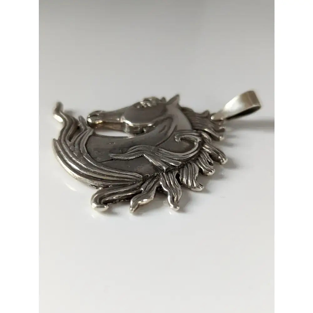 Silver steed mustang horse head silver pendant with detailed mane and flowing lines in polished silver design
