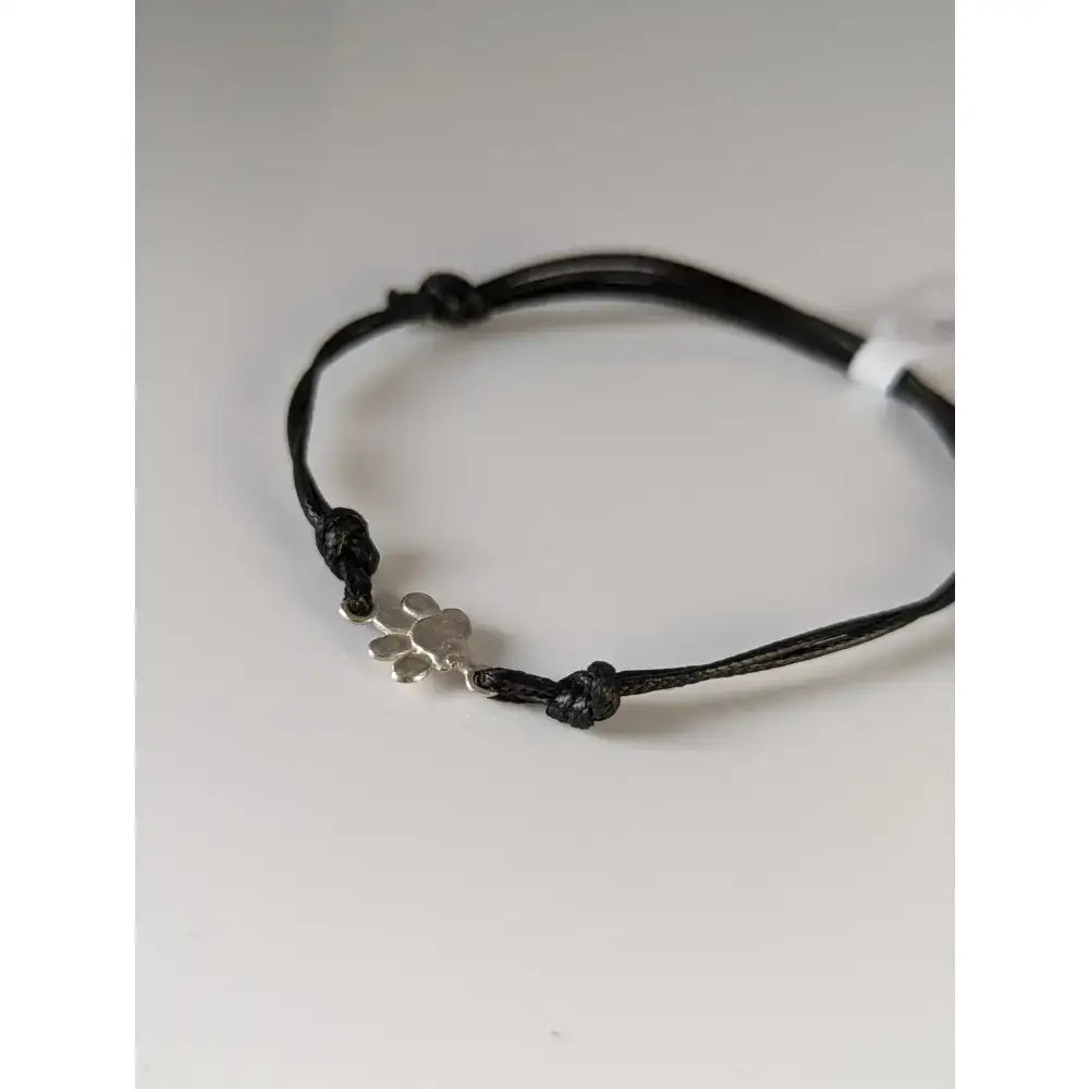 Black cord paw print cord bracelet featuring a silver steed paw print charm for casual wear