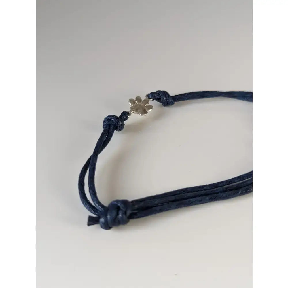 Navy blue cord bracelet with a small silver steed paw print charm perfect as a paw print cord bracelet accessory