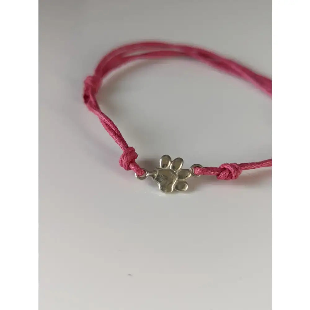 Pink cord paw print cord bracelet featuring a silver steed paw print charm for casual wear