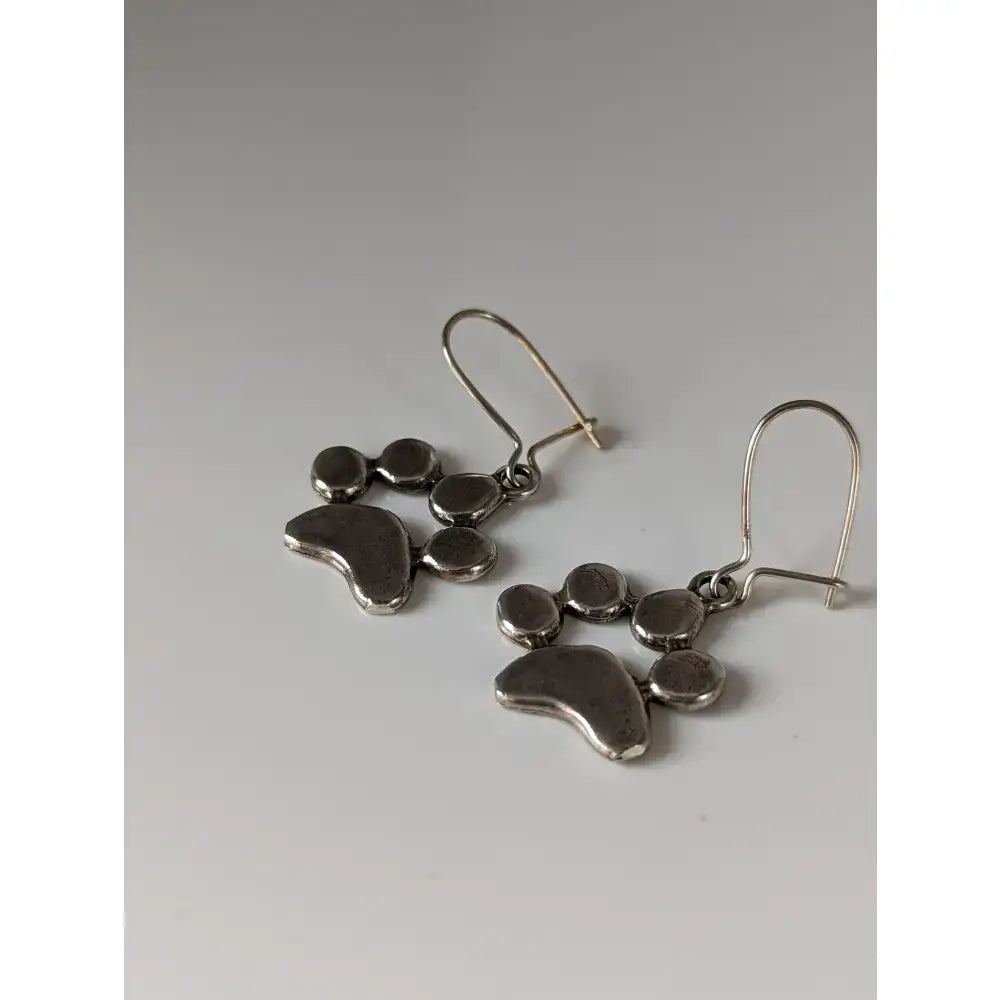 Silver steed paw print silver dropped earrings with textured metallic finish and small circular accents
