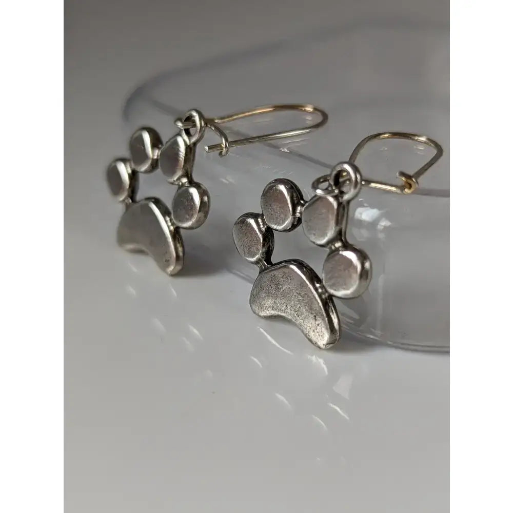 Silver steed paw print silver dropped earrings with textured antiqued finish and simple hook backs in silver