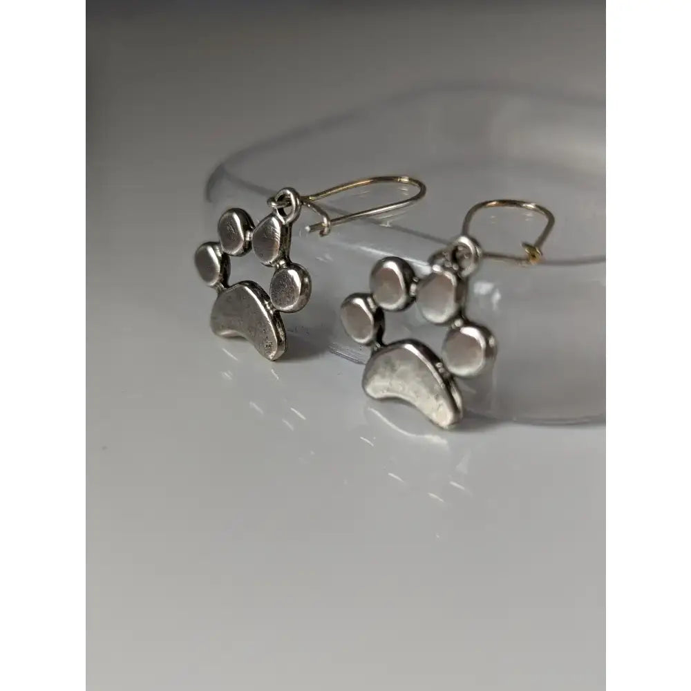 Silver steed paw print silver dropped earrings featuring textured metallic silver paw print design with classic hooks