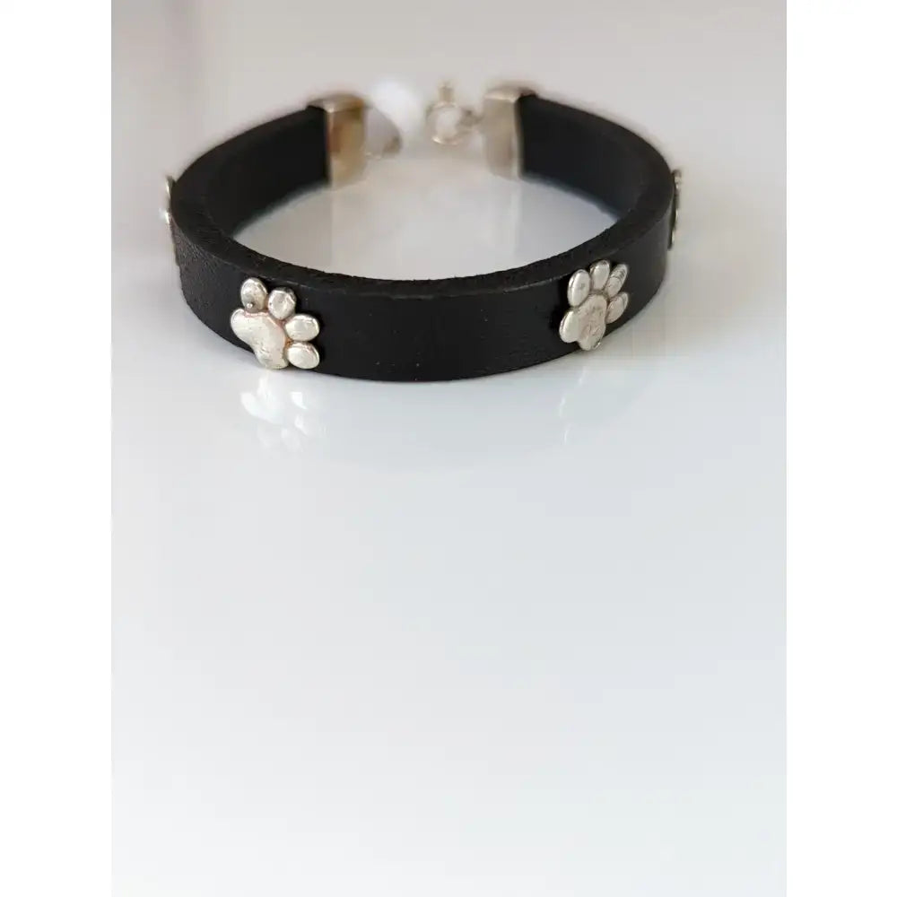 Silver steed black leather bracelet with silver paw print charms and matching clasp for a stylish look