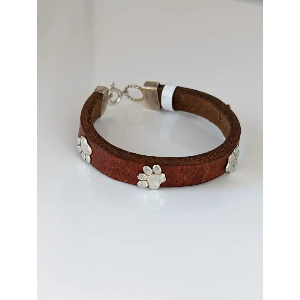 Silver steed leather bracelet with brown leather and silver paw print charms plus a matching metal clasp