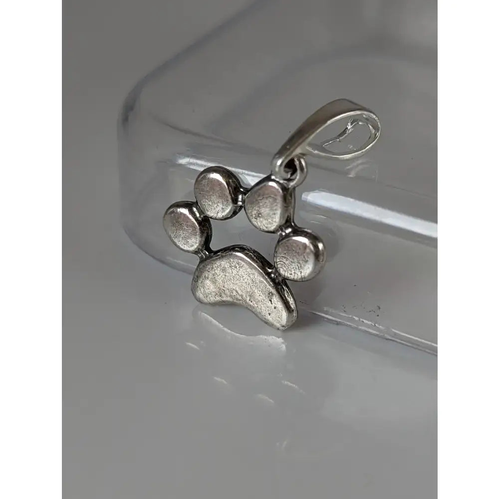 Silver steed paw print silver pendant featuring a textured silver pendant with rounded pads and polished finish