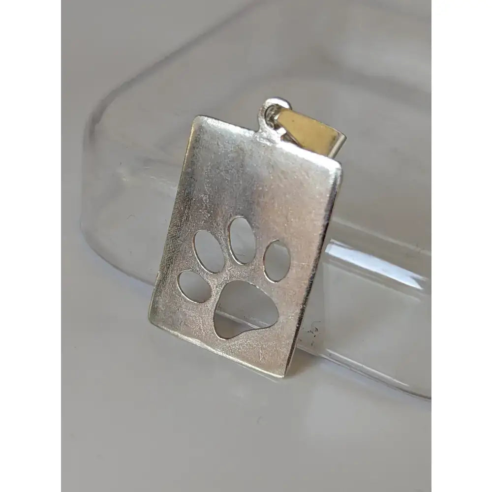 Silver steed paw print tag silver pendant with a silver rectangular pendant and cut-out paw print design and gold bail