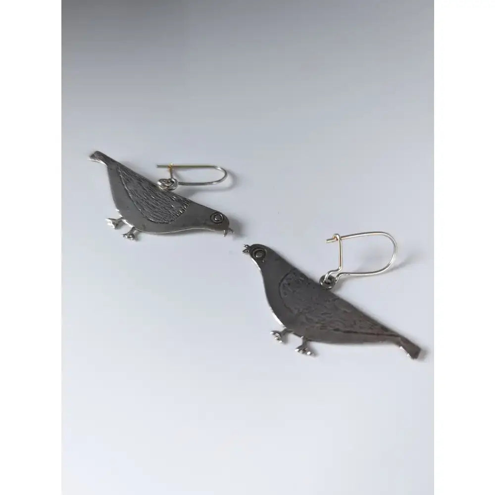 Silver steed pigeon dropped earrings featuring silver pigeon shapes with detailed engraved feathers and small black eyes