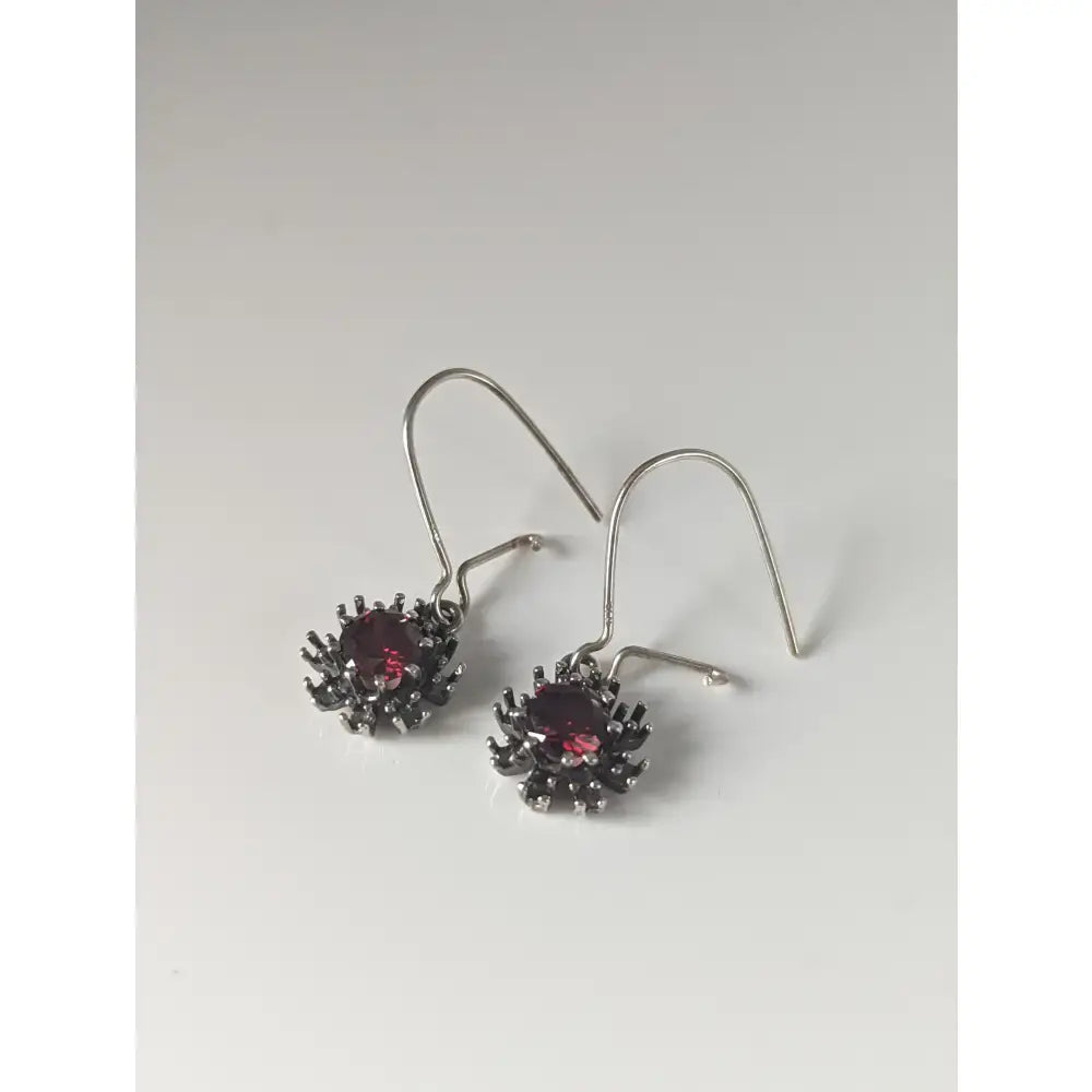 Silver steed red crystal sunflower dropped earrings with deep red gemstone and intricate silver spiky metalwork