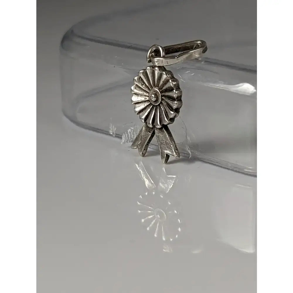 Silver steed rosette silver pendant featuring a silver-toned metallic ribbon charm with detailed petals and bow design