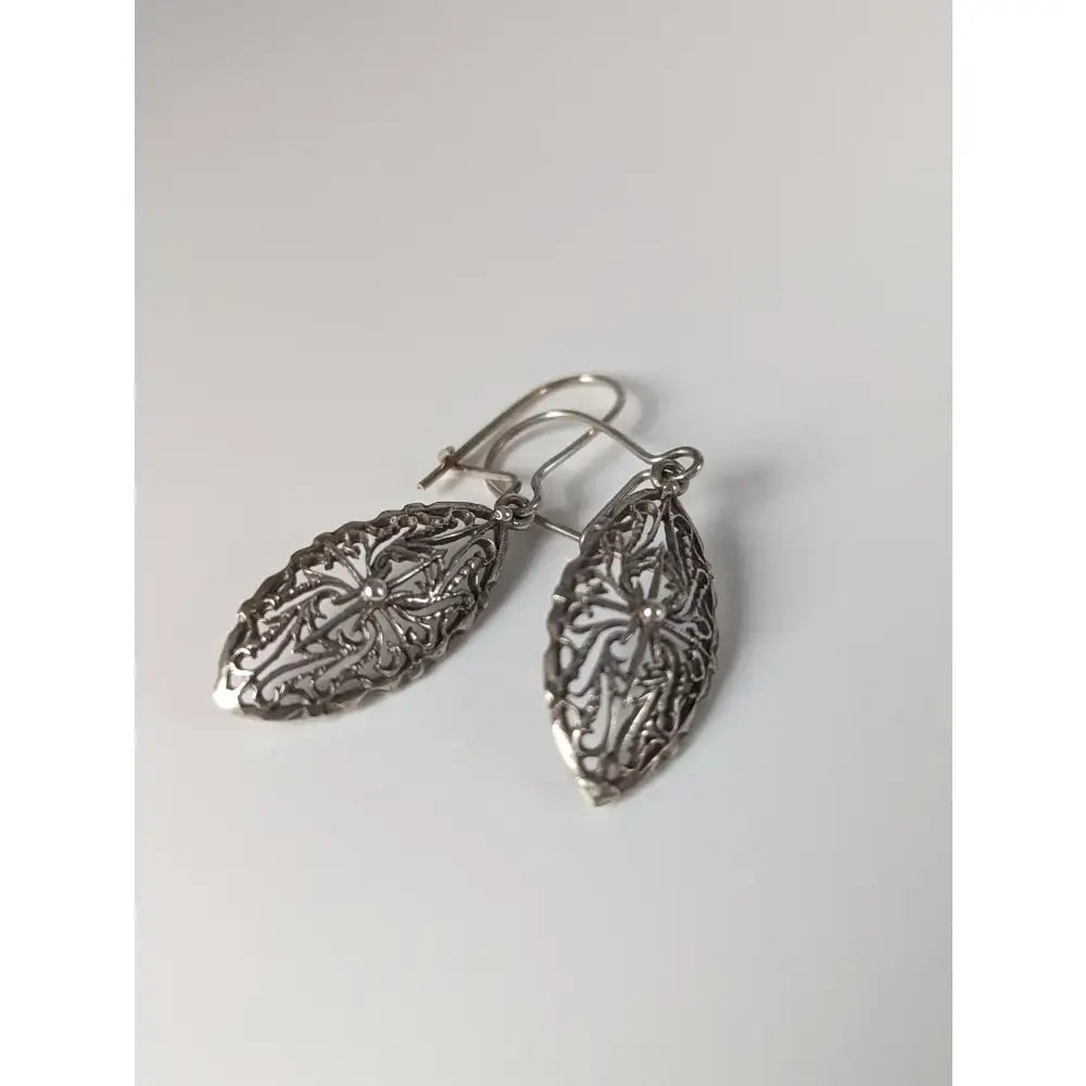 Silver steed shield dropped earrings with intricate floral silver filigree and polished metallic finish