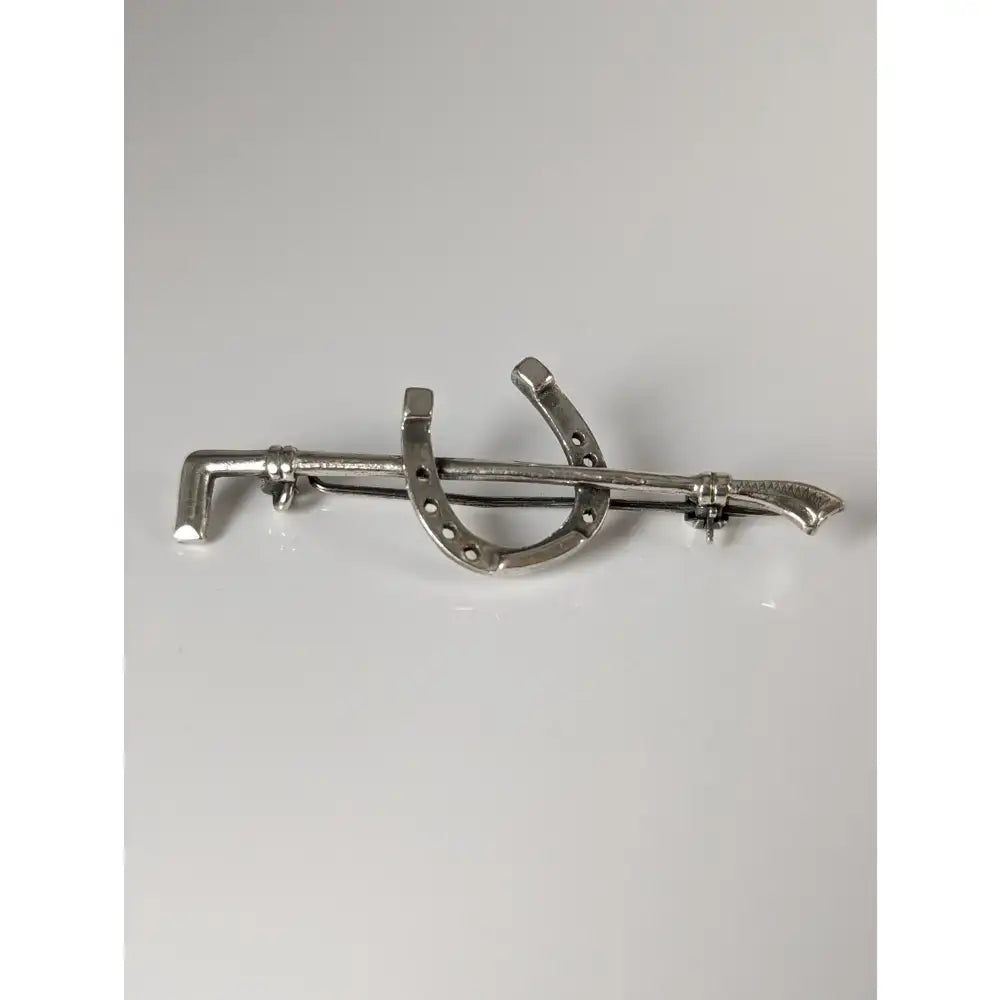 Silver steed shoe stock tie pin and cane silver brooch shaped like a horseshoe crossed with a sword