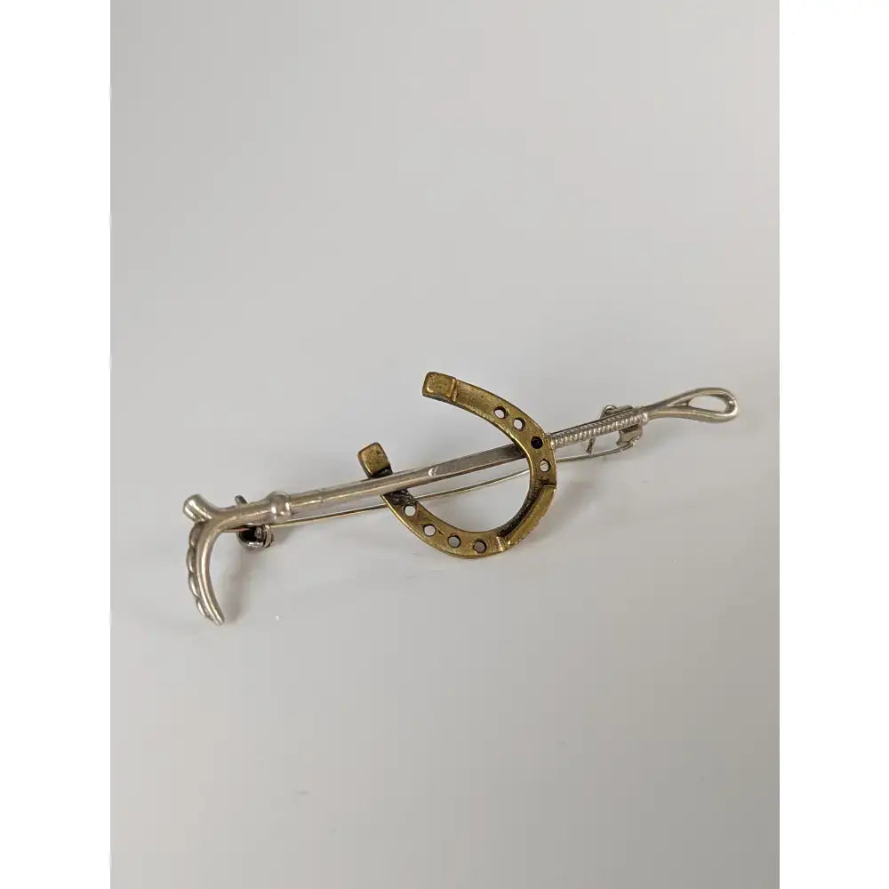 Silver and gold-toned horseshoe pin with curved design perfect as a silver steed shoe stock tie pin or cane gold brooch