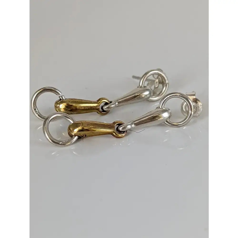 A pair of silver steed snaffle two-tone snaffle bit stud earrings with polished silver and gold sterling silver bit earrings
