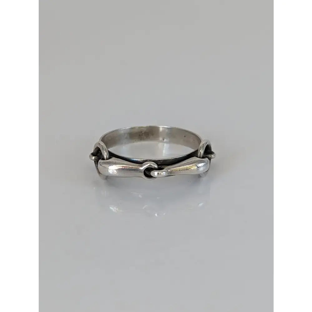 Silver steed snaffle silver horsebit-style ring with polished metallic finish and intricate interlocking design on silver band