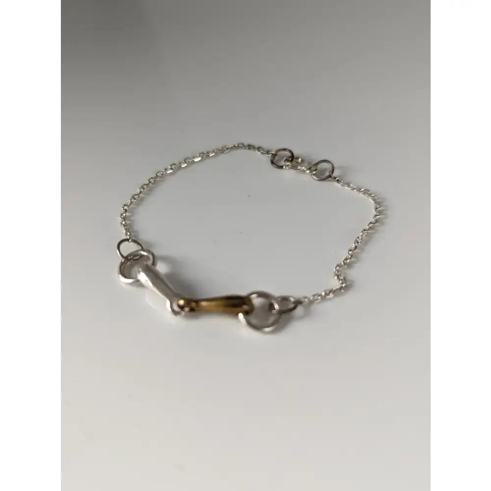 Silver steed snaffle chain delicate bracelet featuring a silver horsebit with a brass center and linked chain design