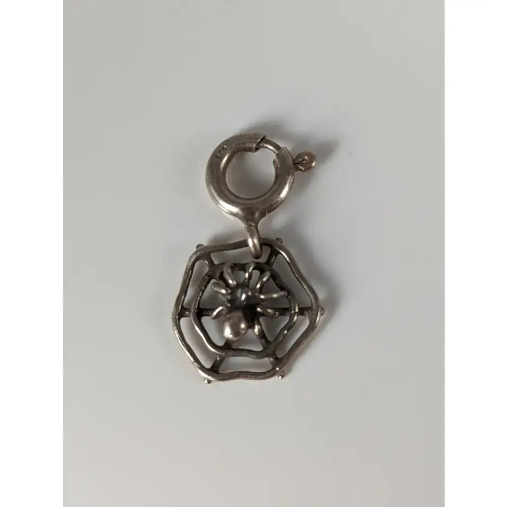 Silver steed spider web silver charm made of metal with a detailed central spider and loop for equestrian jewelry use