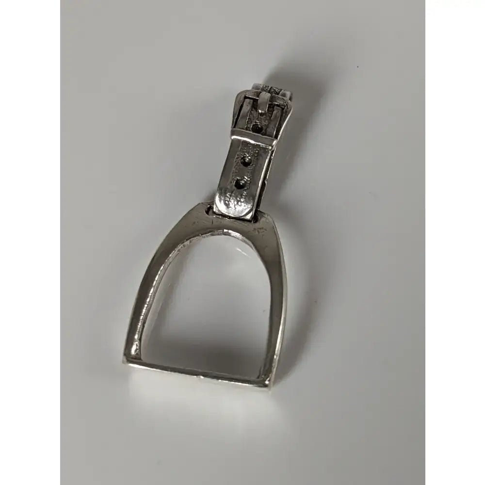 Silver steed stirrup silver pendant showing a silver metal horse stirrup with a buckle at the top