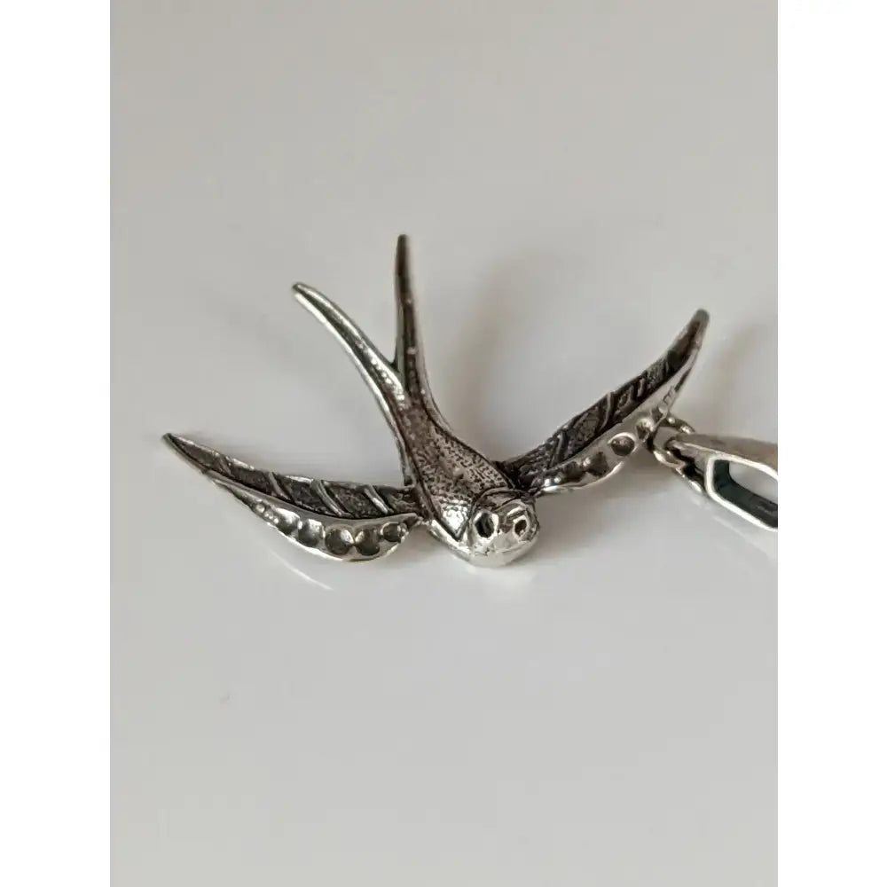 Silver steed swallow silver pendant with detailed feather texture and polished sterling silver finish