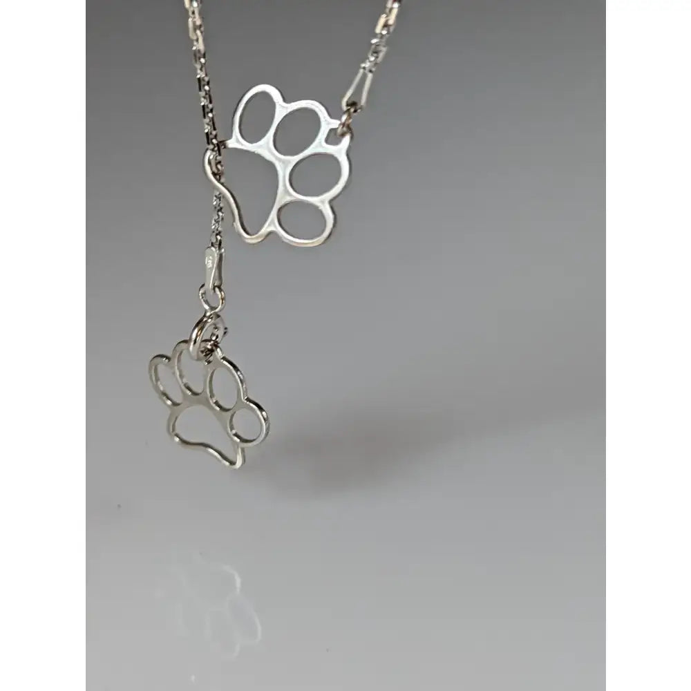 Silver steed thread through double paw print silver necklace with silver pendant and two openwork paw-shaped charms