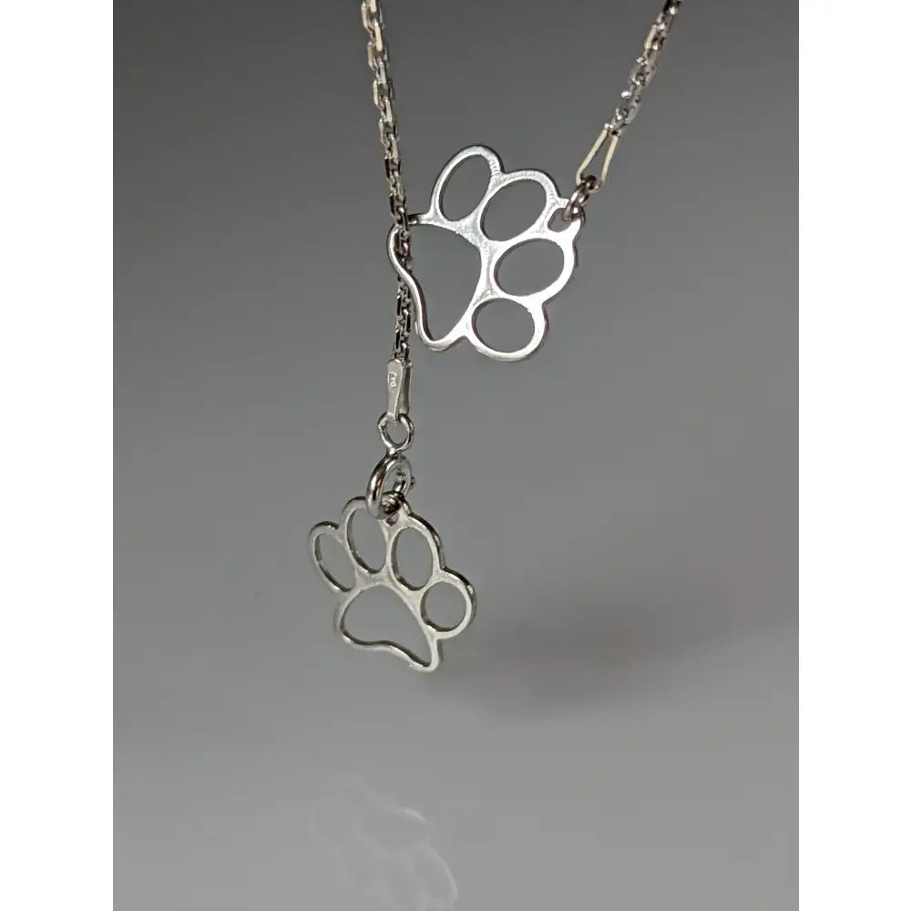 Silver steed thread silver necklace with double paw print pendant and two dangling charms in silver tone